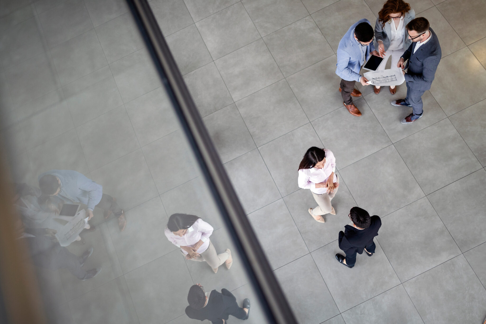 Top view of five business people talking to each other in two groups